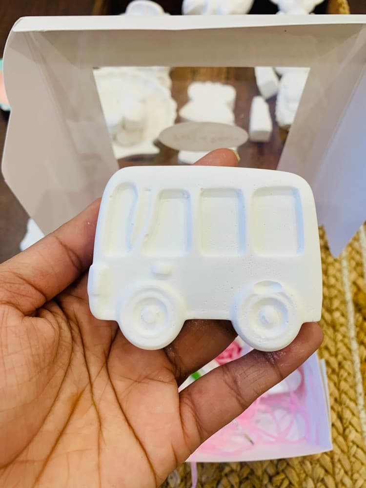 Unpainted white bus figurine held in hand