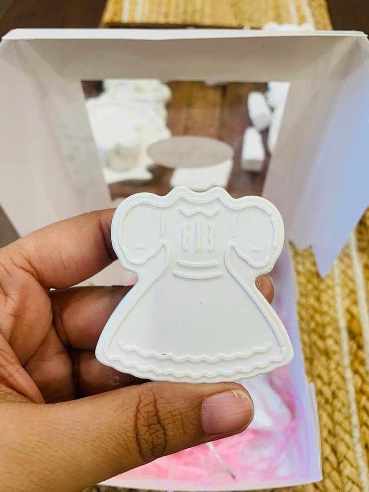 Unpainted white dress figurine held in hand