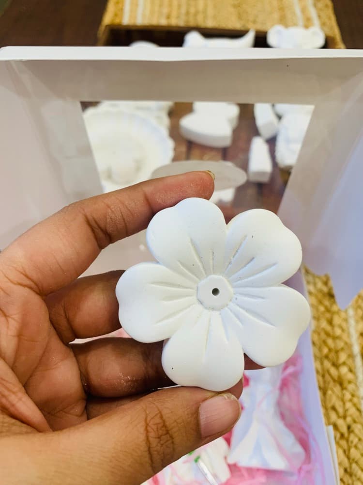 Unpainted white flower figurine held in hand